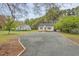 Inviting home with gravel driveway, bordered by landscaping, nestled among mature trees at 1306 Ed Cook Rd, Durham, NC 27703