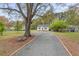 Charming home exterior with gravel driveway, well-maintained landscaping, and mature trees at 1306 Ed Cook Rd, Durham, NC 27703