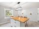 Spacious eat-in kitchen with bright light fixture, butcher block island and access to backyard at 1306 Ed Cook Rd, Durham, NC 27703