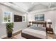 Cozy bedroom with wood floors, stylish decor, with a large TV and a bedside plant at 1306 Ed Cook Rd, Durham, NC 27703