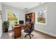 Comfortable home office with a wooden desk, shelves and two large windows for natural light at 1306 Ed Cook Rd, Durham, NC 27703