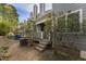 View of townhouse backyard featuring trees, patio, and HVAC equipment at 1426 Quarter Pt, Raleigh, NC 27615