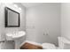 Half bathroom featuring a pedestal sink, framed mirror, and hardwood floors at 1426 Quarter Pt, Raleigh, NC 27615