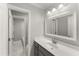 Bright bathroom with vanity, mirror and an open doorway to the tub-shower combo at 1426 Quarter Pt, Raleigh, NC 27615