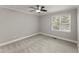 Clean and simple bedroom with neutral carpet, ceiling fan, and natural light from the window at 1426 Quarter Pt, Raleigh, NC 27615