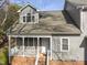 Charming two-story home featuring a covered porch with white railings and gray siding, plus red brick stairs and facade at 1426 Quarter Pt, Raleigh, NC 27615