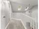 Carpeted hallway with white banister and fan with two skylights at 1426 Quarter Pt, Raleigh, NC 27615