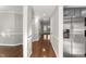 Hallway leading to the kitchen with stainless steel refrigerator, hardwood floors and grey walls at 1426 Quarter Pt, Raleigh, NC 27615