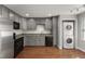 Modern kitchen with stainless steel appliances, gray cabinets, and hardwood floors at 1426 Quarter Pt, Raleigh, NC 27615