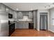 Well-lit kitchen with gray cabinetry, stainless appliances, and functional washer/dryer at 1426 Quarter Pt, Raleigh, NC 27615