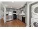 Updated kitchen featuring stainless steel appliances, grey cabinets, and beautiful hardwood floors at 1426 Quarter Pt, Raleigh, NC 27615