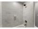 Close up of a modern tiled bathtub and shower with updated fixtures at 1426 Quarter Pt, Raleigh, NC 27615