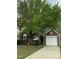 Charming brick home with a well-maintained lawn and a large tree providing shade at 144 Gremar Dr, Holly Springs, NC 27540