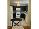 Efficient kitchen features white appliances, dark cabinets and views to the dining area at 144 Gremar Dr, Holly Springs, NC 27540