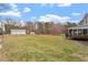 Backyard with metal outbuildings, a home, and an enclosed porch is seen at 15 Longwood Dr, Youngsville, NC 27596