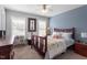 Cozy bedroom featuring a ceiling fan, two windows, and a queen-sized bed with patterned quilts at 15 Longwood Dr, Youngsville, NC 27596