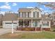 Charming two-story home with a well-manicured lawn, attached garage and inviting front porch at 15 Longwood Dr, Youngsville, NC 27596