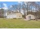 A detached three-car garage, a storage building, and a grassy lawn are viewed at 15 Longwood Dr, Youngsville, NC 27596