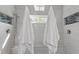 Updated walk-in shower features white tile and a glass partition for a clean, modern aesthetic at 15 Longwood Dr, Youngsville, NC 27596