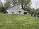Gray home featuring a fenced backyard, mature trees, and a detached garage at 1609 Evergreen St, Durham, NC 27703