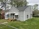 Side view of gray home featuring a fenced yard, mature trees, and a small porch at 1609 Evergreen St, Durham, NC 27703
