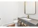 Modern half bathroom featuring a stone countertop, sleek gold mirror, and minimalist design at 1621 Bruce Circle, Raleigh, NC 27604