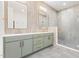 Modern bathroom featuring a double vanity, framed mirrors, tiled walls, and glass-enclosed shower at 1621 Bruce Circle, Raleigh, NC 27604