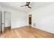 A bright and airy bedroom with light hardwood floors, ceiling fan, and view to the bathroom at 1621 Bruce Circle, Raleigh, NC 27604