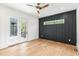 Spacious bedroom with natural light, black accent wall, ceiling fan, and doors to the outdoor patio at 1621 Bruce Circle, Raleigh, NC 27604