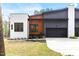 Stylish home exterior featuring a white brick accent, wood detail, and black garage door at 1621 Bruce Circle, Raleigh, NC 27604