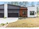 Modern duplex featuring a gray and white exterior, black garage doors, and manicured landscaping at 1625 Bruce Circle, Raleigh, NC 27604