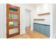 Bright foyer with a wood door, hardwood floors, blue cabinetry, and white walls, creating a modern entrance at 1625 Bruce Circle, Raleigh, NC 27604