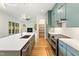 Modern kitchen with blue cabinets, white countertops, and stainless appliances, flowing into the living area at 1625 Bruce Circle, Raleigh, NC 27604
