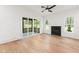 Bright living room featuring hardwood floors, a fireplace, and sliding doors leading to a screened porch at 1625 Bruce Circle, Raleigh, NC 27604