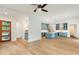 Open-concept living space with light hardwood floors, a ceiling fan, and a view into the modern kitchen at 1625 Bruce Circle, Raleigh, NC 27604