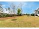 Spacious backyard with green lawn, patio with outdoor grill, and black metal fencing at 1629 Montvale Grant Way, Cary, NC 27519
