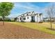 Expansive backyard featuring a modern white home, patio area, and manicured lawn at 1629 Montvale Grant Way, Cary, NC 27519
