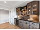 Chic bar area with wood cabinets, shelves, mini fridge, and a dark countertop at 1629 Montvale Grant Way, Cary, NC 27519
