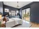 Inviting bedroom with a walkout to the backyard and a dark accent wall with a chandelier at 1629 Montvale Grant Way, Cary, NC 27519