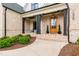Inviting front porch with brick columns, a stylish wood door, and manicured landscaping at 1629 Montvale Grant Way, Cary, NC 27519