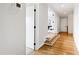 Hallway with hardwood floors, white walls, and entrances to various rooms within the house at 1629 Montvale Grant Way, Cary, NC 27519