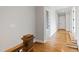 Hallway with hardwood floors and white walls, leading to another room with decorated wallpaper at 1629 Montvale Grant Way, Cary, NC 27519