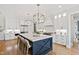 Modern kitchen with white cabinetry, stainless steel appliances, large island with seating, and stylish pendant lighting at 1629 Montvale Grant Way, Cary, NC 27519