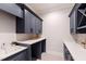 Well-designed laundry room with blue cabinets, white countertops, and hexagon tiled floors at 1629 Montvale Grant Way, Cary, NC 27519