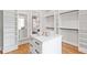 Spacious walk-in closet features custom organizers, center island, hardwood floors, and a makeup mirror at 1629 Montvale Grant Way, Cary, NC 27519