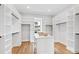 Large walk-in closet with custom shelves, drawers, hardwood floors and a center island for storage at 1629 Montvale Grant Way, Cary, NC 27519