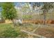 Picturesque backyard with a storage shed, stepping stone path, garden, mature trees, and a wooden fence at 1903 Yellowwood Ln, Durham, NC 27712