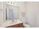 Powder room featuring a wood vanity, mirror, and white toilet at 1903 Yellowwood Ln, Durham, NC 27712