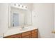 Bathroom vanity with a white countertop, oak cabinets and a large mirror at 1903 Yellowwood Ln, Durham, NC 27712