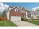 Two-story brick home with blue shutters, manicured lawn, and attached two car garage at 1903 Yellowwood Ln, Durham, NC 27712